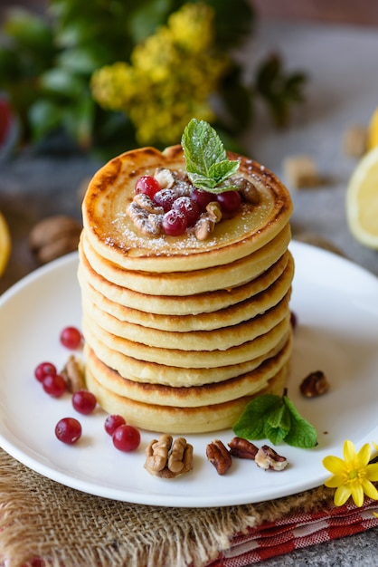 Deliciosas panquecas frescas frescas com mel cítrico e geléia. Delicioso café da manhã quente com panquecas com frutas e bagas