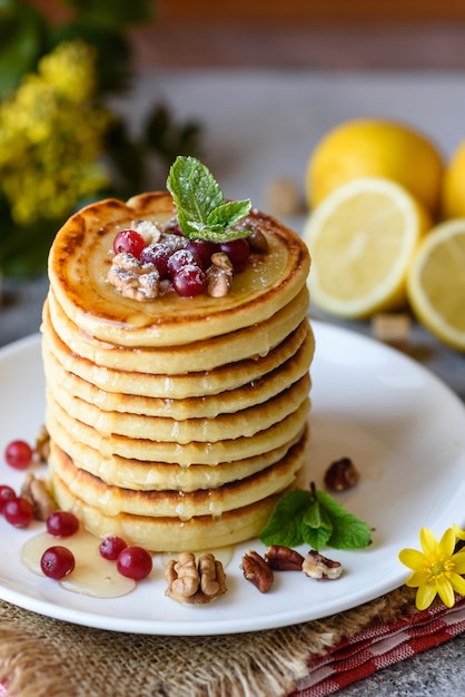 Deliciosas panquecas frescas frescas com mel cítrico e geléia. Delicioso café da manhã quente com panquecas com frutas e bagas