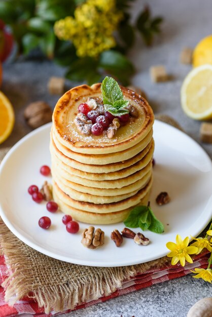 Deliciosas panquecas frescas frescas com mel cítrico e geléia. Delicioso café da manhã quente com panquecas com frutas e bagas