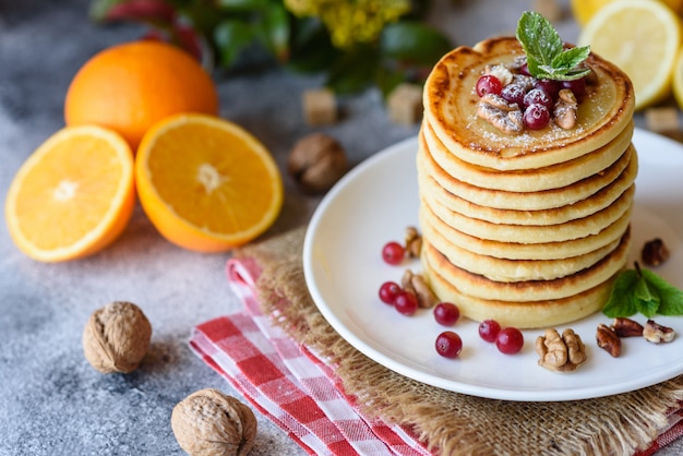 Deliciosas panquecas frescas frescas com mel cítrico e geléia. Delicioso café da manhã quente com panquecas com frutas e bagas