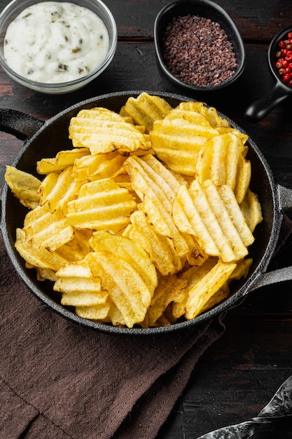 Deliciosas papas fritas crujientes, con crema agria, sobre la mesa de madera antigua