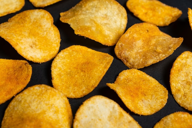 Foto deliciosas papas fritas crujientes con especias en una vista superior de fondo negro