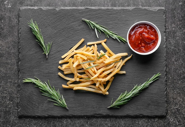 Deliciosas papas fritas en placa de pizarra