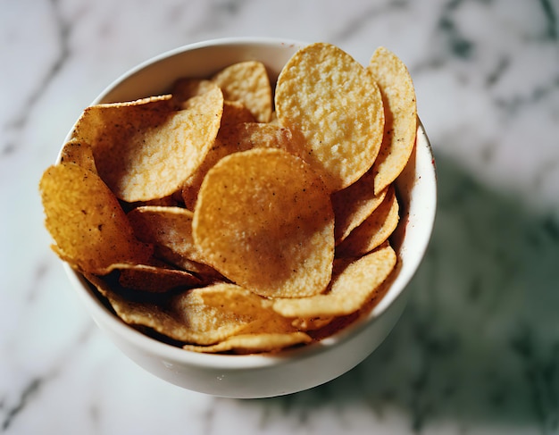 Deliciosas papas fritas en un plato blanco profundo sobre una mesa de mármol con vista superior generada por IA