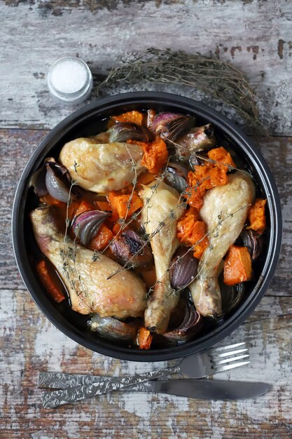 Foto deliciosas patas de pollo al horno con calabaza y cebolla azul. keto paleo. pegan