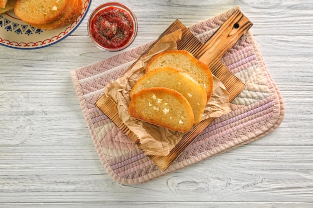 Deliciosas rebanadas de pan francés con ajo sobre una mesa de madera
