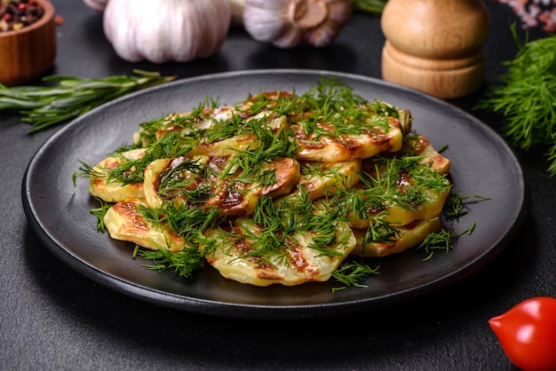 Deliciosas rodajas de patata a la parrilla con especias y hierbas en un plato negro