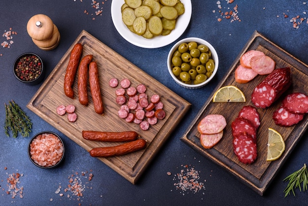 Deliciosas salchichas ahumadas frescas cortadas en rodajas sobre una tabla para cortar madera