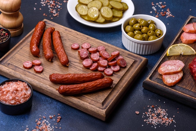 Deliciosas salchichas ahumadas frescas cortadas en rodajas sobre una tabla para cortar madera