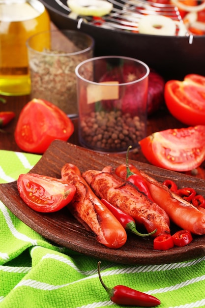 Foto deliciosas salsichas com legumes no prato na mesa de madeira closeup