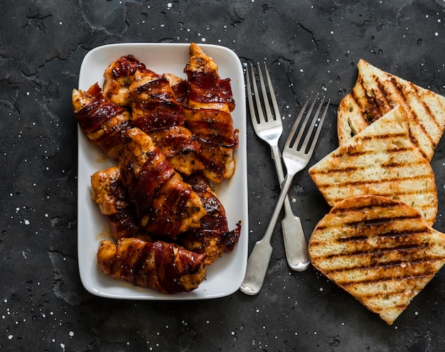 Deliciosas tapas de pechuga de pollo al horno envuelta en pan a la parrilla con tocino