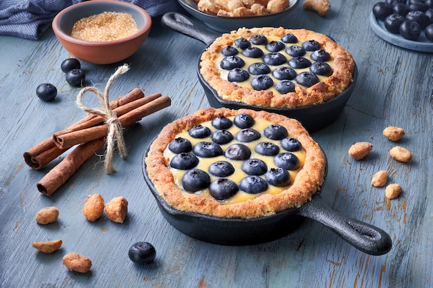 Deliciosas tartaletas de arándanos con crema de vainilla en azul claro