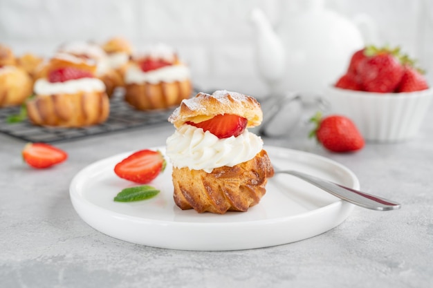 Deliciosas tartas caseras de hojaldre Profiterole con natillas de fresa y glaseado en polvo