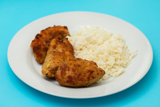 Deliciosas tiras de peito de frango empanadas e crocantes com arroz cozido