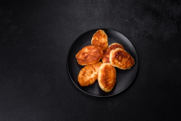 Deliciosas tortas caseiras com batatas em um fundo escuro de concreto