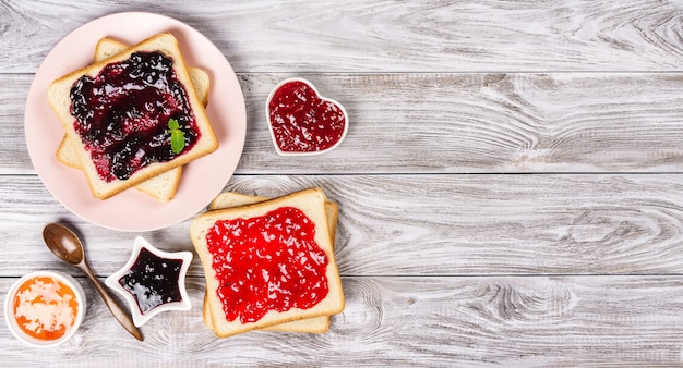 Deliciosas tostadas con varias mermeladas dulces. Copyspace para tu texto