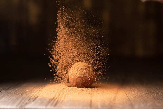 Deliciosas trufas de chocolate espolvoreadas con cacao sobre un fondo reflectante negro