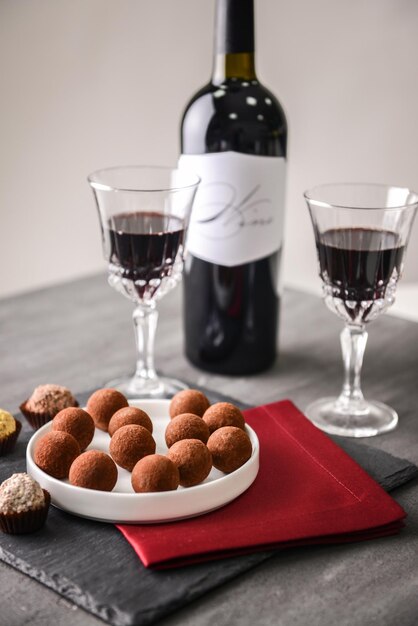 Deliciosas trufas de chocolate y vino tinto sobre fondo gris