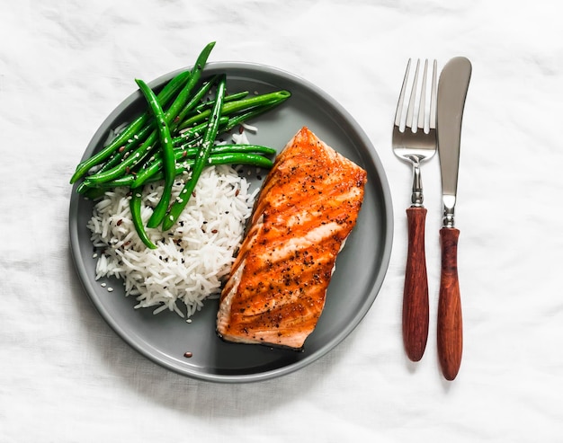 Delicioso almoço saudável, arroz basmati de salmão grelhado e vagens verdes em uma vista superior de fundo leve