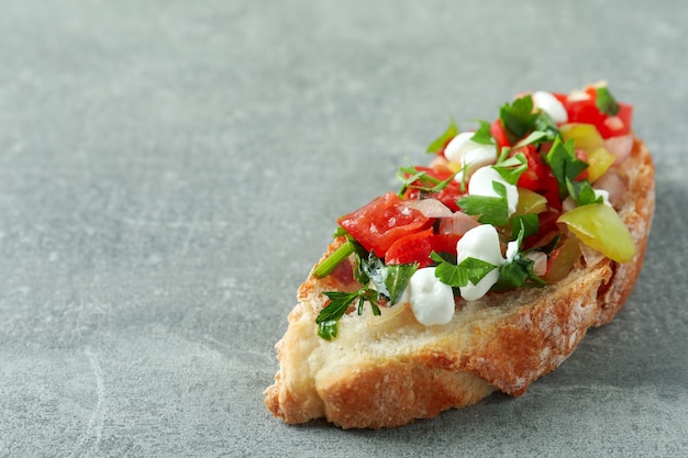 Delicioso aperitivo italiano bruschetta sobre fondo de textura gris