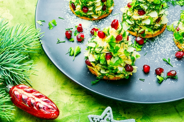 Delicioso aperitivo para a mesa de Natal. Canapés com queijo, alho e romã.