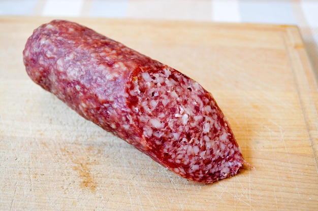 Delicioso y apetitoso salami de salchicha roja en una tabla de cortar de abedul