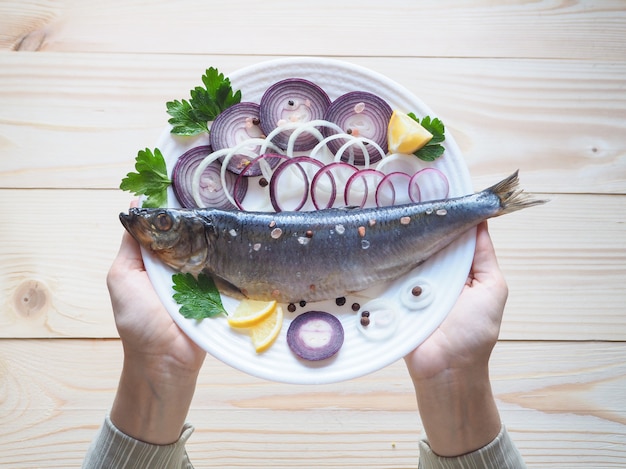Un delicioso arenque de pescado salado en el plato. La cocina mediterránea y rusa.