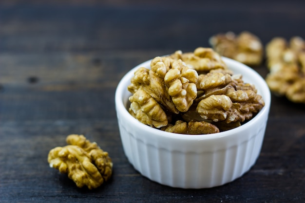 Delicioso arreglo de nueces en un recipiente sobre una mesa de madera.