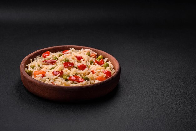 Delicioso arroz hervido con verduras, pimientos, zanahorias, guisantes y espárragos