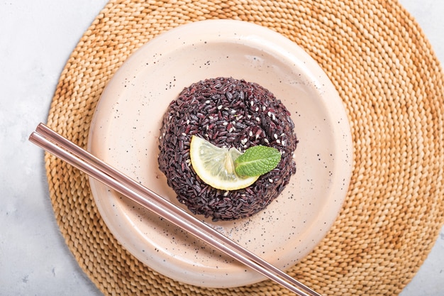 Delicioso arroz negro cocido o risotto con palillos. Vista desde arriba