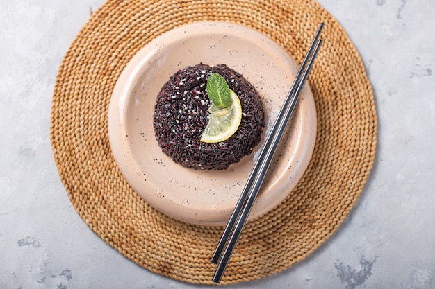 Delicioso arroz negro cocido o risotto con palillos. Vista desde arriba