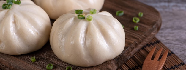 Foto delicioso baozi pan de carne al vapor chino está listo para comer en el plato de servicio y vaporizador copia de cerca el concepto de diseño de producto espacial