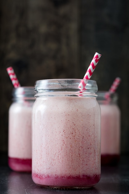 Delicioso batido de fresa en frasco en la mesa de madera