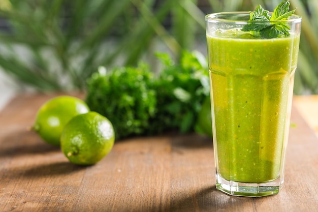 Delicioso batido verde saludable con frutas y verduras en la mesa