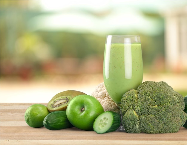 Delicioso batido verde saludable con frutas y verduras en la mesa