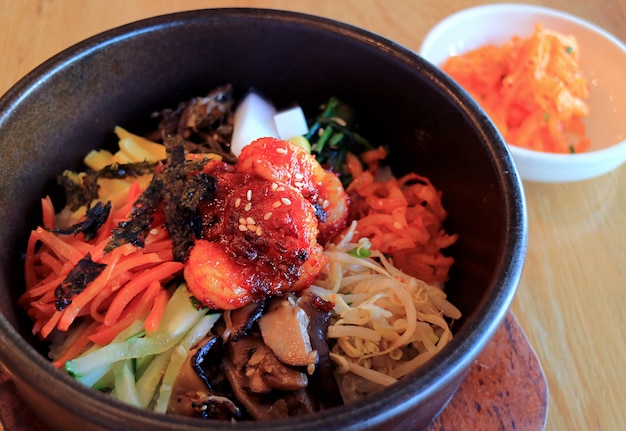 Delicioso Bibimbap, um arroz tradicional coreano misturado com carne e vegetais variados em uma tigela de pedra quente