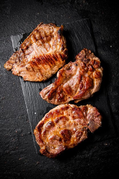 Foto delicioso bistec de cerdo a la parrilla en una tabla de piedra