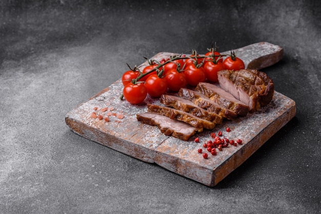 Delicioso bistec jugoso de cerdo o ternera a la parrilla con especias saladas y hierbas sobre un fondo de hormigón texturizado