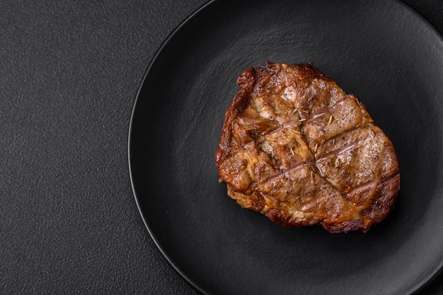 Delicioso bistec jugoso de cerdo o ternera a la parrilla con sal, especias y hierbas