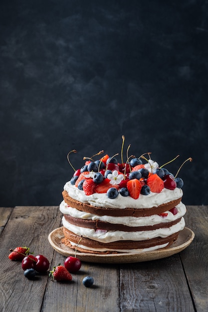 Delicioso bizcocho de chocolate con crema de queso y frutas del bosque