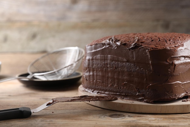 Delicioso bolo caseiro com creme de chocolate na mesa de madeira fechada