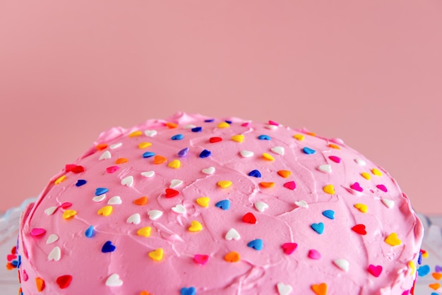 Delicioso bolo com cobertura de chantilly rosa no fundo rosa