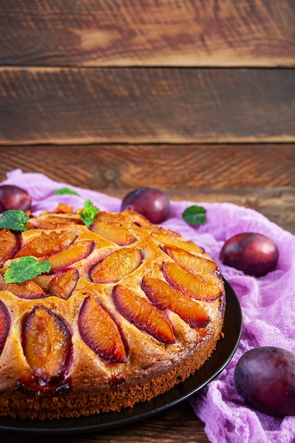 Delicioso bolo de ameixa com fundo de madeira. torta caseira de ameixa