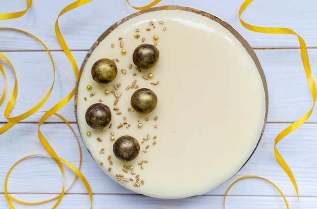 Delicioso bolo de caramelo com doces redondos de chocolate polvilhados