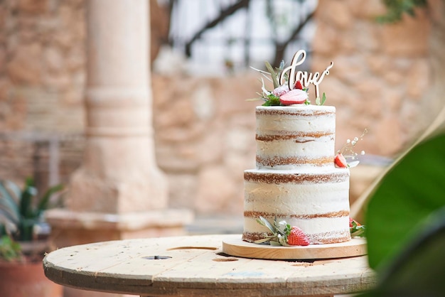 Delicioso bolo de casamento nu na mesa de madeira que copia o espaço