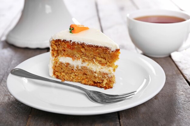 Delicioso bolo de cenoura com chá na mesa de madeira