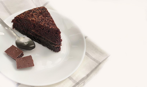 Delicioso bolo de chocolate em um prato na mesa sobre um fundo claro