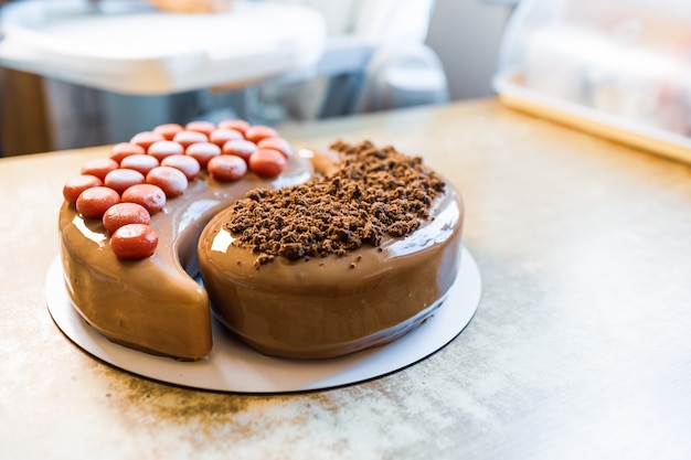 Delicioso bolo de chocolate maravilhoso em forma de Yin-Yang em uma aconchegante cozinha caseira em uma mesa vintage de madeira