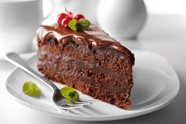 Delicioso bolo de chocolate no prato na mesa na luz de fundo