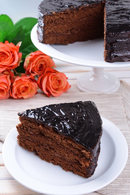 Delicioso bolo de chocolate no prato na mesa na luz de fundo